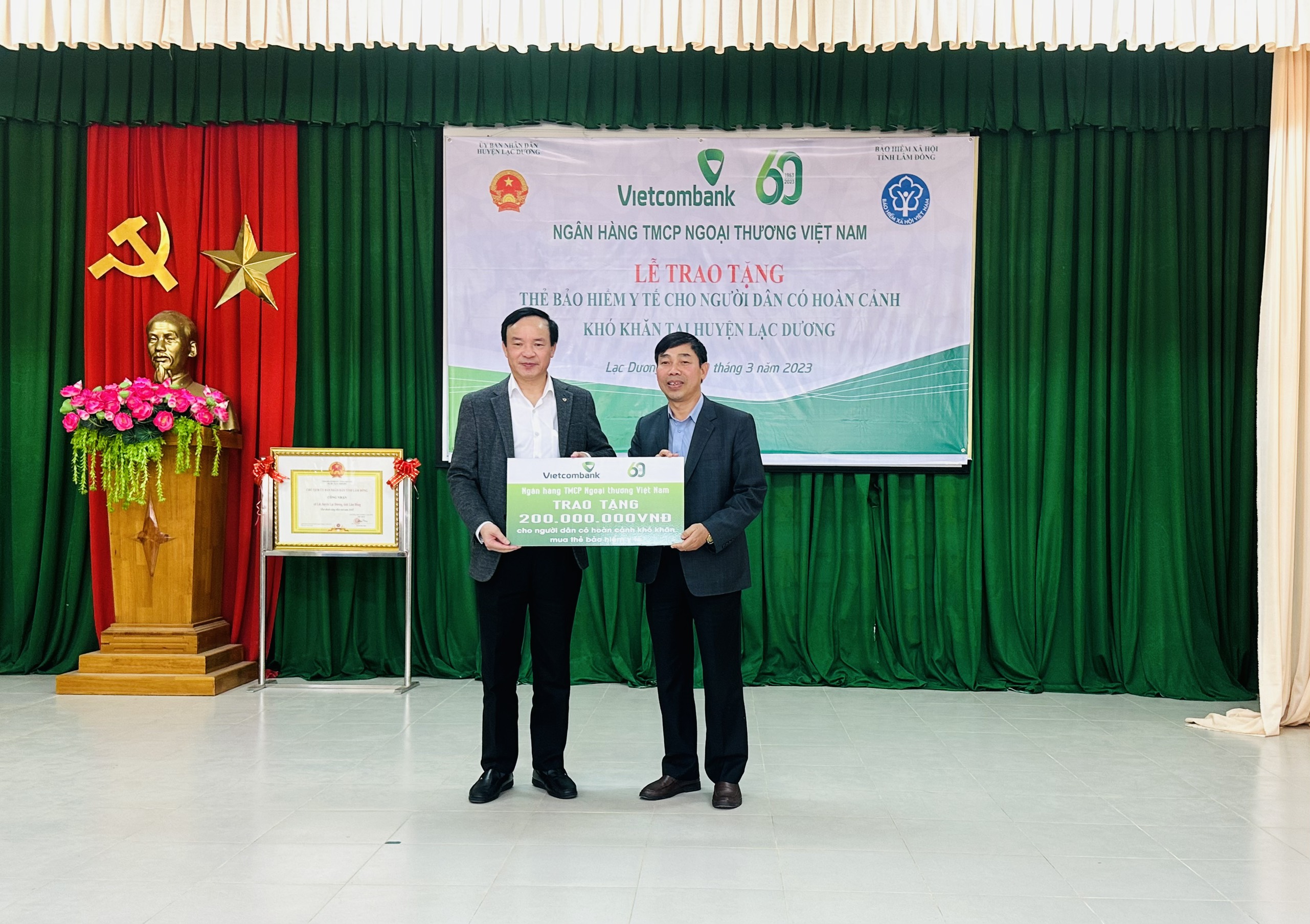 Ông Nguyễn Văn Chiểu - Giám đốc Ngân hàng Vietcombank Lâm Đồng trao bảng ghi nhận tài trợ 200 triệu đồng cho ông Đậu Tú Lan –Giám đốc Bảo hiểm Xã hội Lâm Đồng để tặng thẻ BHYT cho người dân có hoàn cảnh khó khăn